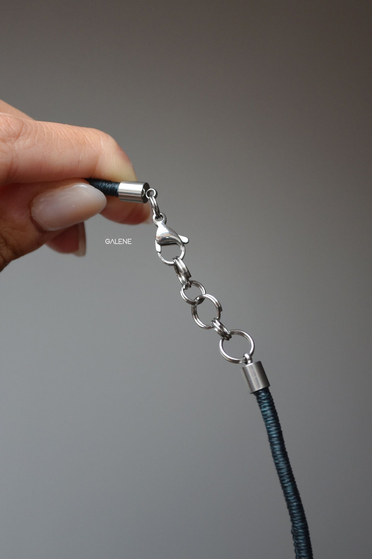 dettaglio sulla chiusura in acciaio inox della collana lumière