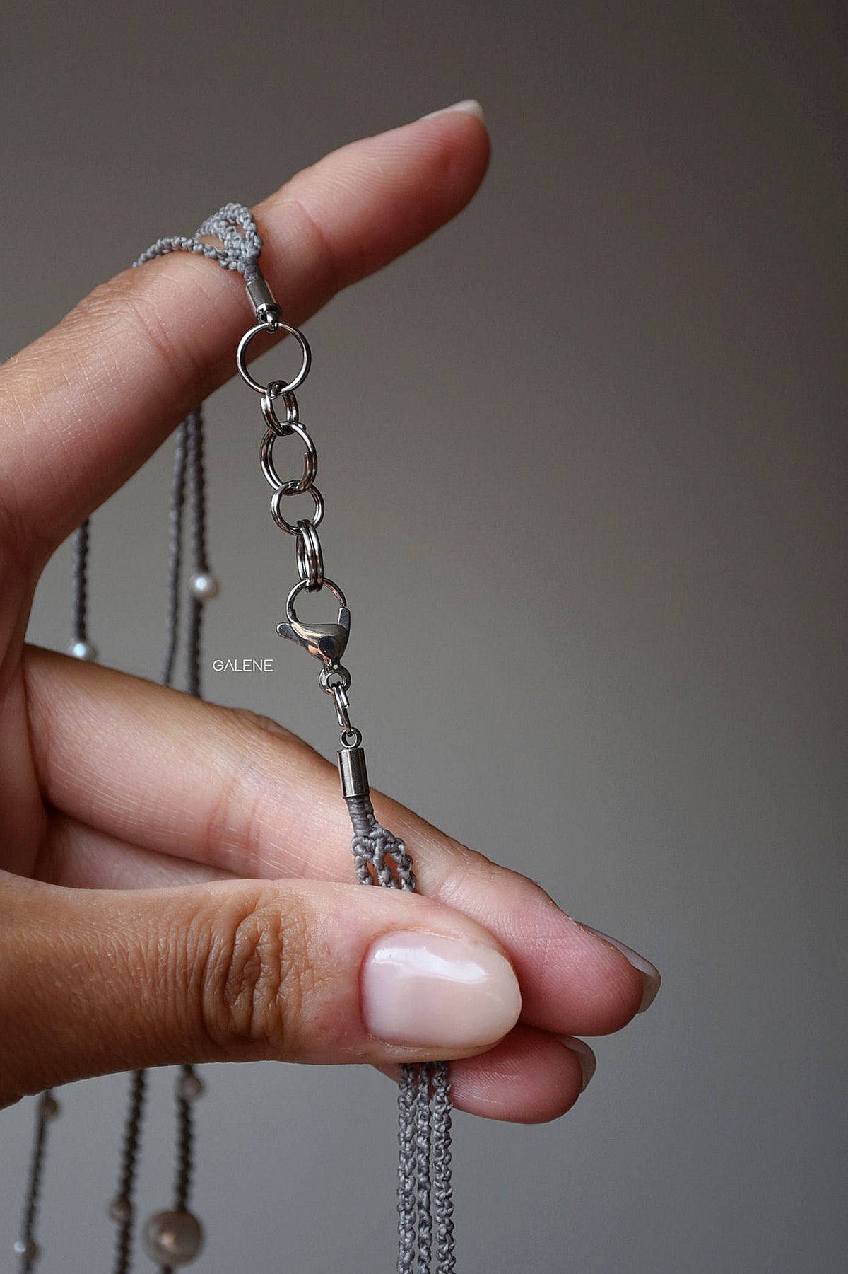 particolare della chiusura della collana in acciaio inox con moschettone e anellini.